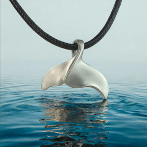 Pendentif en forme de queue de baleine sur fond marin, symbole élégant pour les passionnés de plongée et d'océan. 🌊