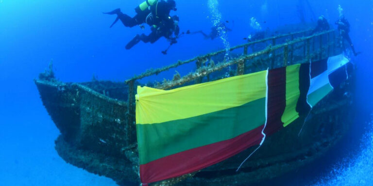 Plongée sous-marine près d'un épave décorée de drapeaux colorés. Exploration marine fascinante.