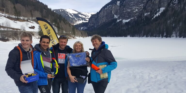 Groupe d'experts en plongée sous-marine dans un paysage alpin enneigé.