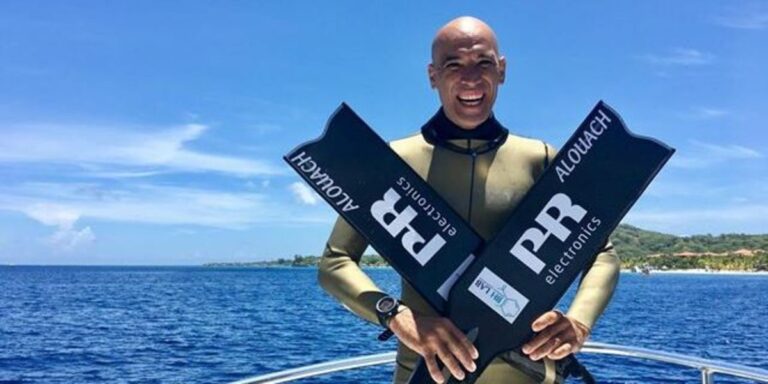 Homme en combinaison de plongée avec palmes, prêt pour l'aventure sous-marine.