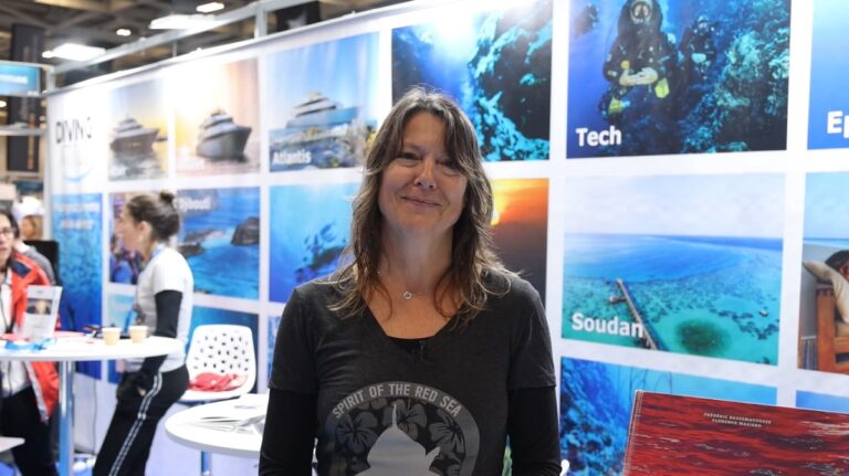 Femme souriante dans un salon de plongée sous-marine, ambiance maritime et exploration.