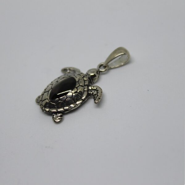 pendentif tortue noir Ce pendentif en forme de tortue, orné d'une pierre noire, évoque la beauté mystérieuse des fonds marins. #Océan