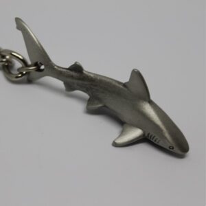 Porte-clés en forme de requin, symbole du monde sous-marin et de la biodiversité marine.