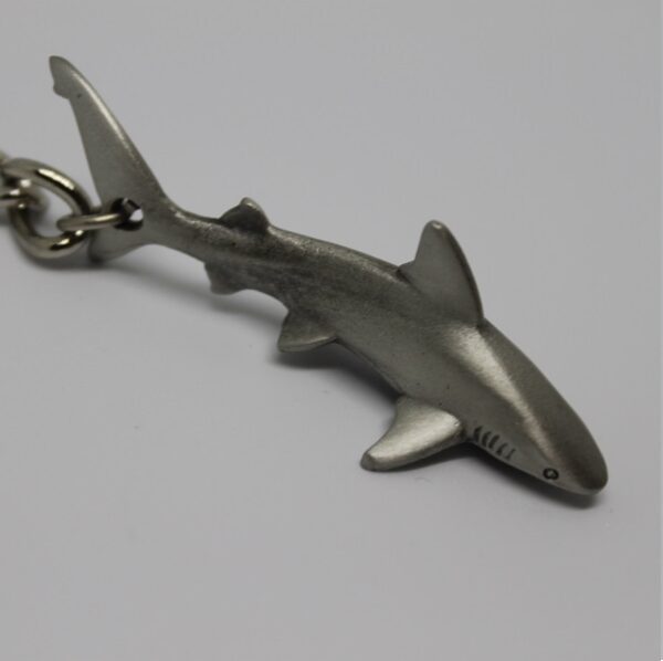 Porte-clés en forme de requin, symbole du monde sous-marin et de la biodiversité marine.