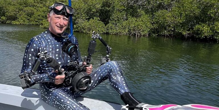 Un plongeur équipé d'une combinaison à motifs et d'un appareil photo sous-marin se prépare à explorer les mangroves. #Plongée