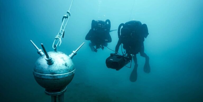 Deux plongeurs démineurs explorent les profondeurs marines, illustrant la sécurité sous-marine essentielle. 🐠