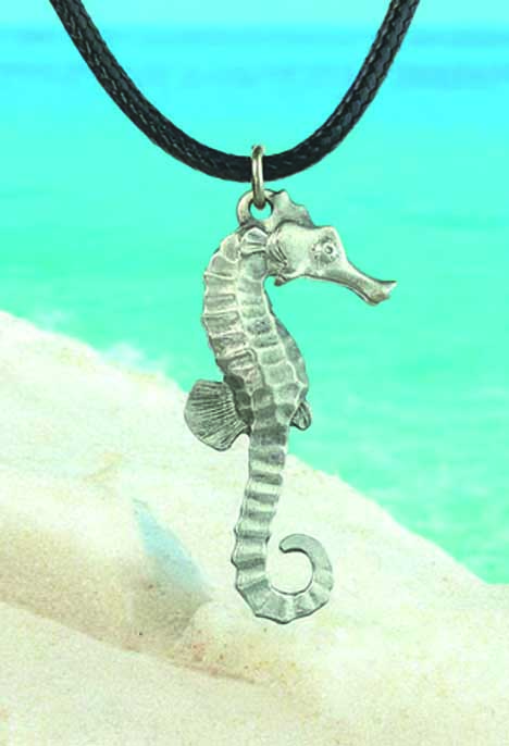 hippo Un pendentif hippocampe repose sur le sable, évoquant l'élégance mystérieuse des récifs coralliens.