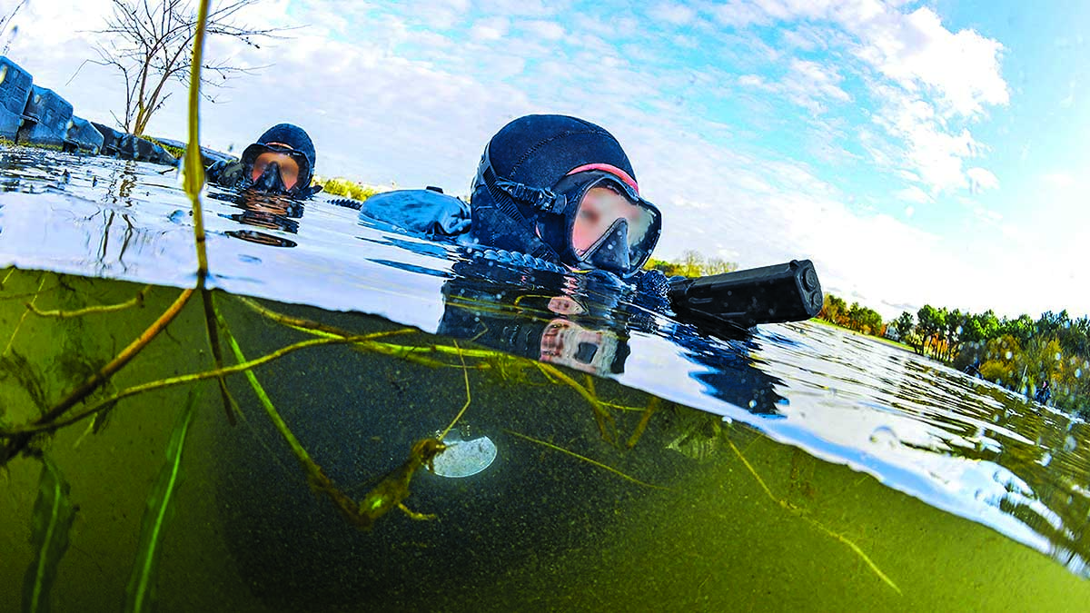Des plongeurs en tenue tactique émergent discrètement d'une eau calme, illustrant l'art de la plongée furtive. #AventureAq...