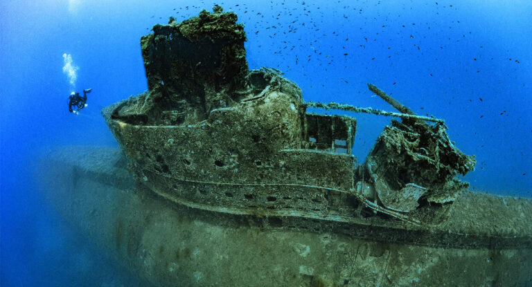 Un plongeur explore l'épave majestueuse d'un navire englouti, témoin silencieux des mystères sous-marins. #Épave
