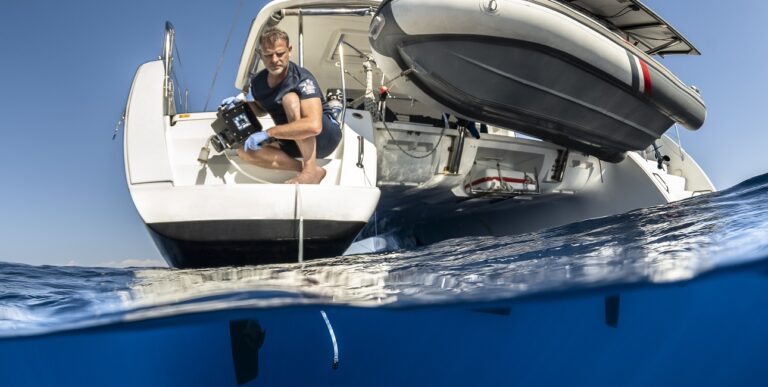 Un chercheur collecte des échantillons d'ADN environnemental depuis un bateau, illustrant l'importance de la conservation ...