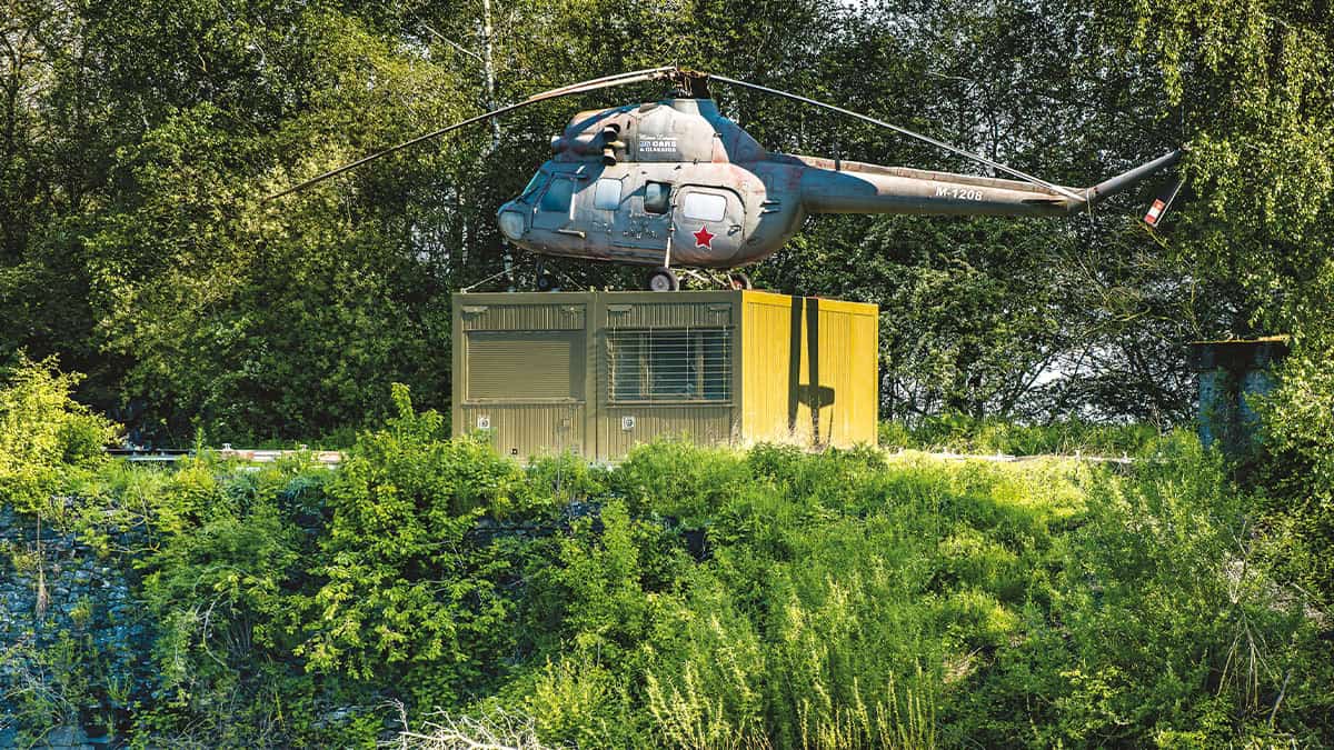Un hélicoptère abandonné surplombe une carrière verdoyante, offrant un cadre insolite pour les amateurs d'aventure subaqua...