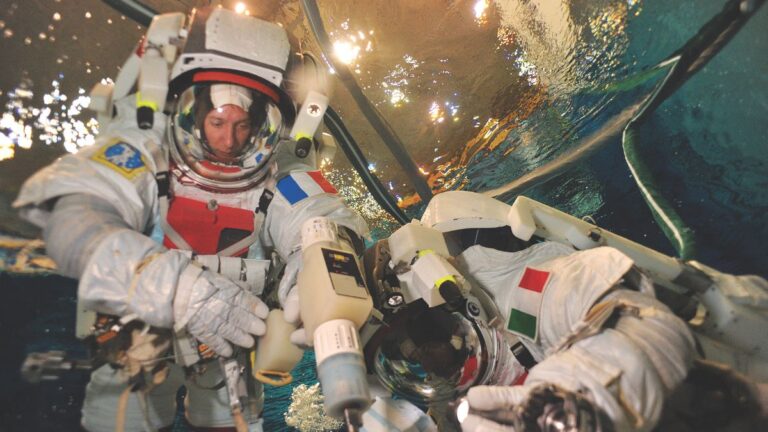 Deux astronautes s'entraînent en piscine pour simuler l'apesanteur, illustrant l'intersection fascinante entre plongée et ...