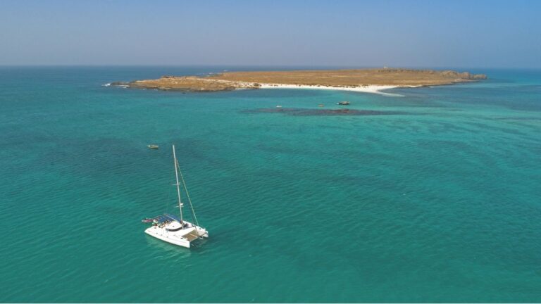 Un catamaran navigue paisiblement dans les eaux turquoise de São Nicolau, offrant une escapade idyllique pour les amateurs...