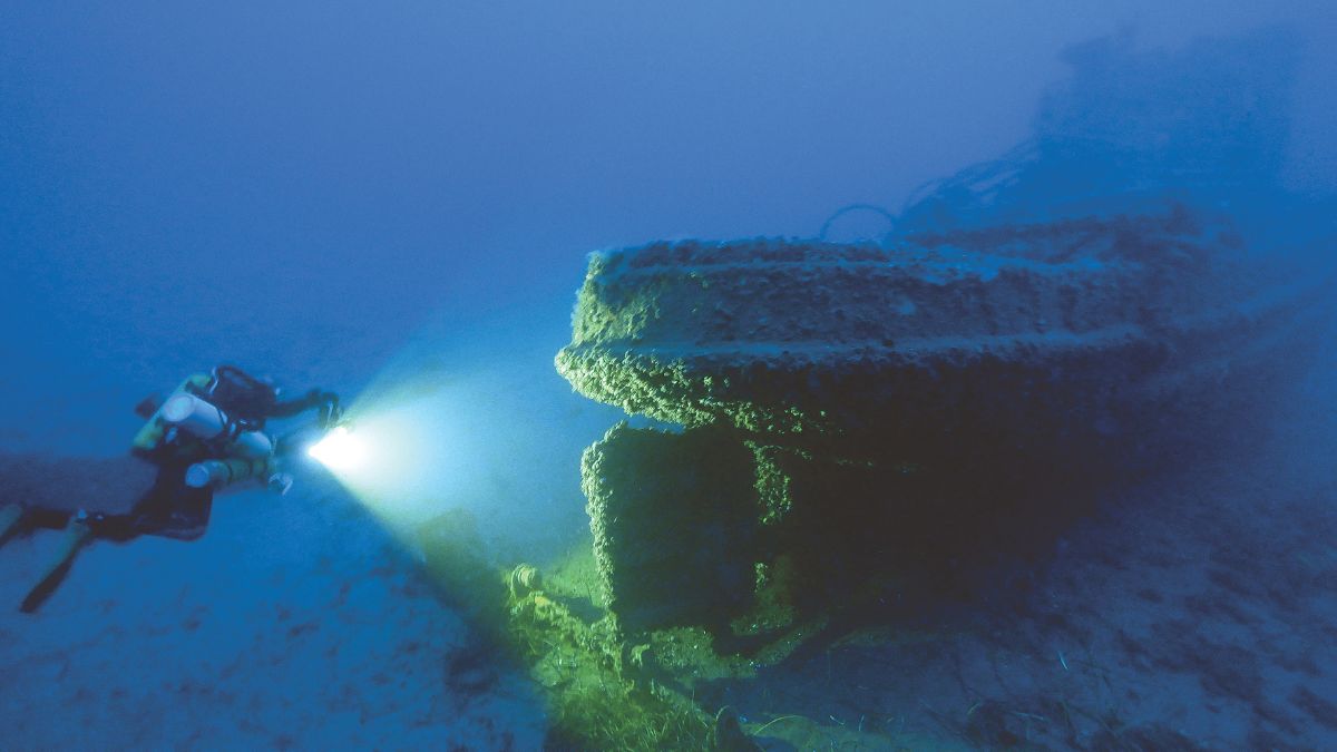 Un plongeur explore une épave mystérieuse, éclairée par sa lampe, révélant les secrets cachés des profondeurs marines. #Av...