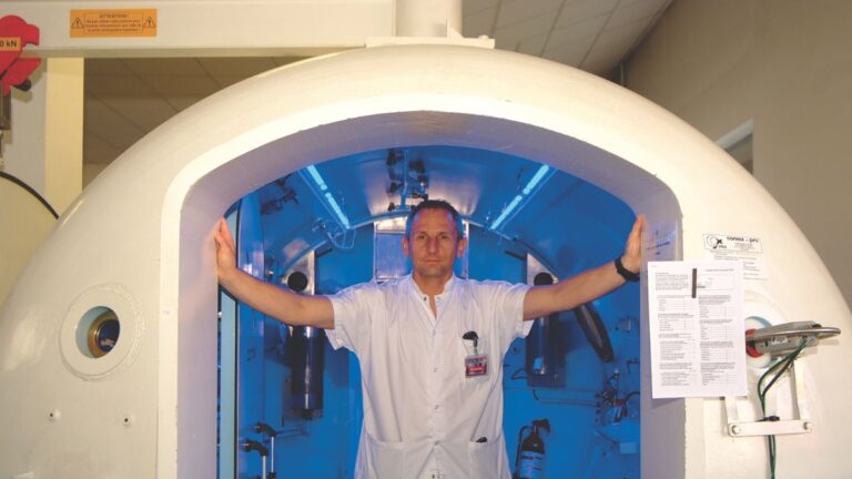 Un professionnel présente une chambre hyperbare, essentielle pour la sécurité des plongeurs et le traitement des accidents...
