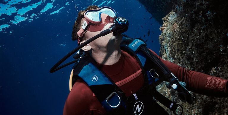Un plongeur explore les profondeurs marines, entouré de poissons, illustrant l'aventure sous-marine.