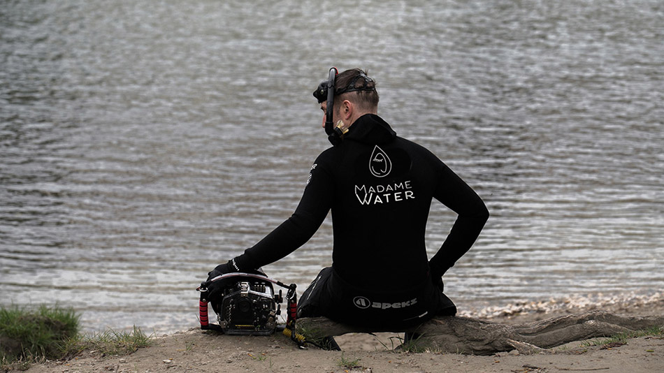 Plongeur préparant son équipement pour une aventure sous-marine dans un environnement aquatique.