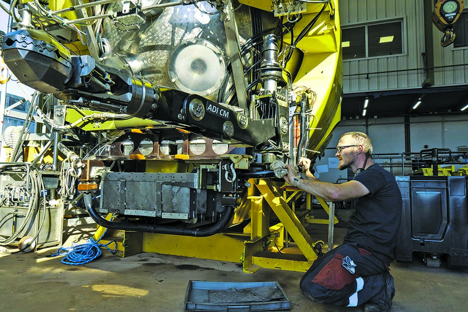 Technicien effectuant l'entretien d'un submersible pour l'exploration sous-marine.