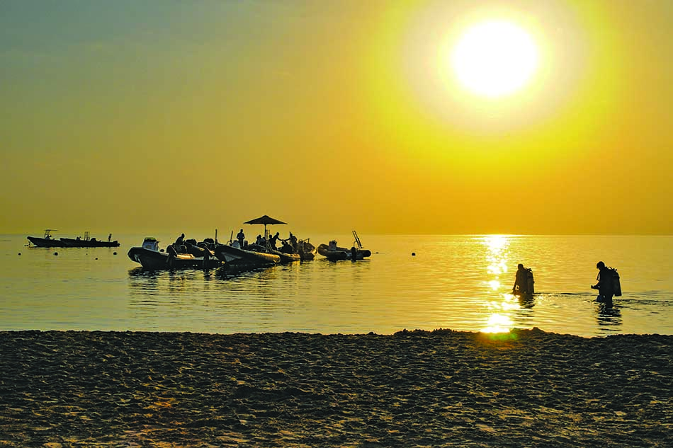 Plongée au coucher du soleil avec des plongeurs se préparant à explorer les fonds marins.