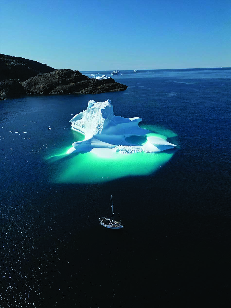 Un majestueux iceberg flotte dans des eaux cristallines, offrant un spectacle fascinant pour les plongeurs.