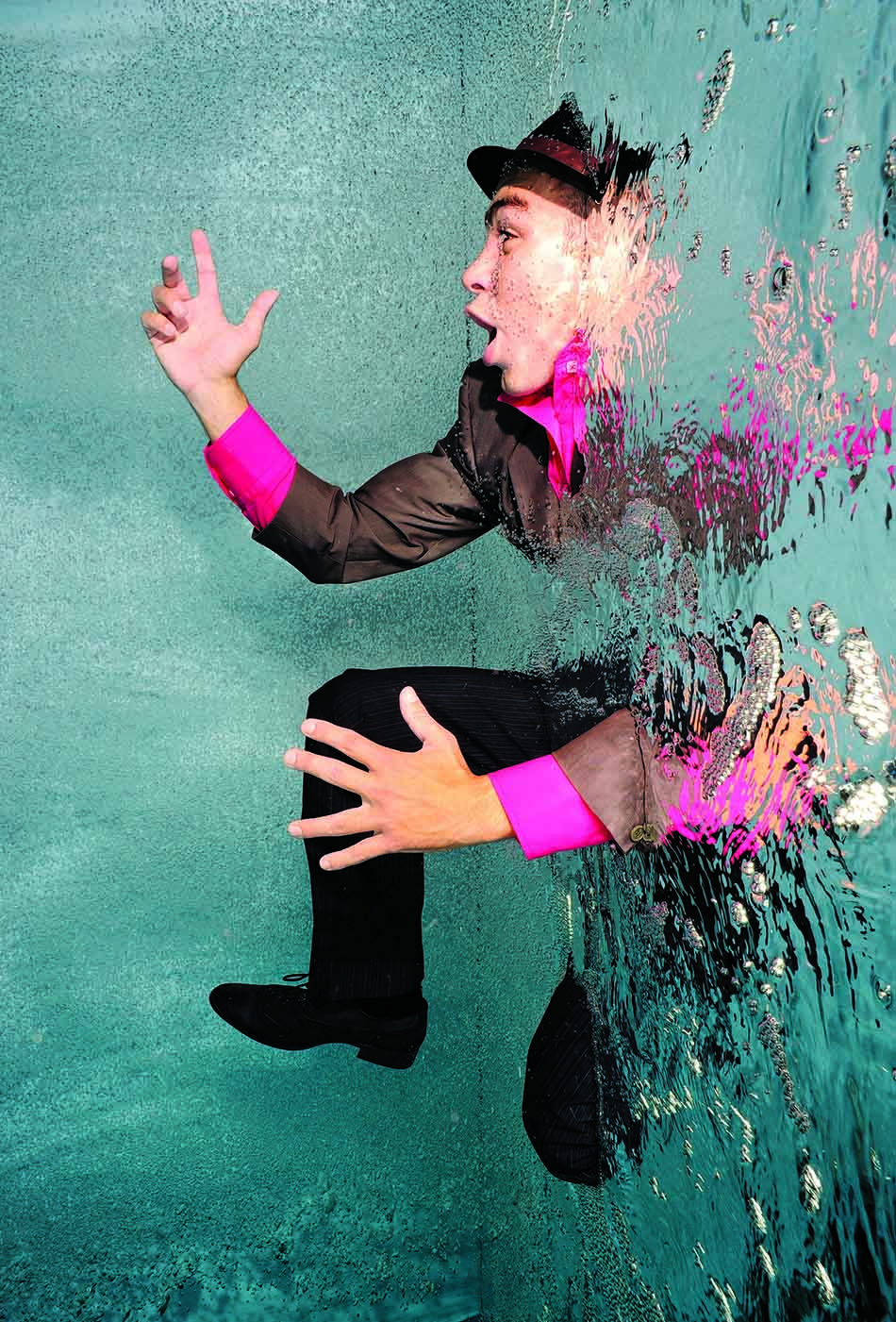 Un plongeur en costume fait face à l'eau, illustrant l'interaction entre l'homme et le monde sous-marin.