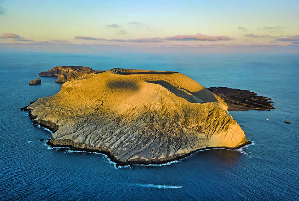 Île volcanique entourée d'eaux turquoise, idéale pour la plongée sous-marine et l'exploration marine.